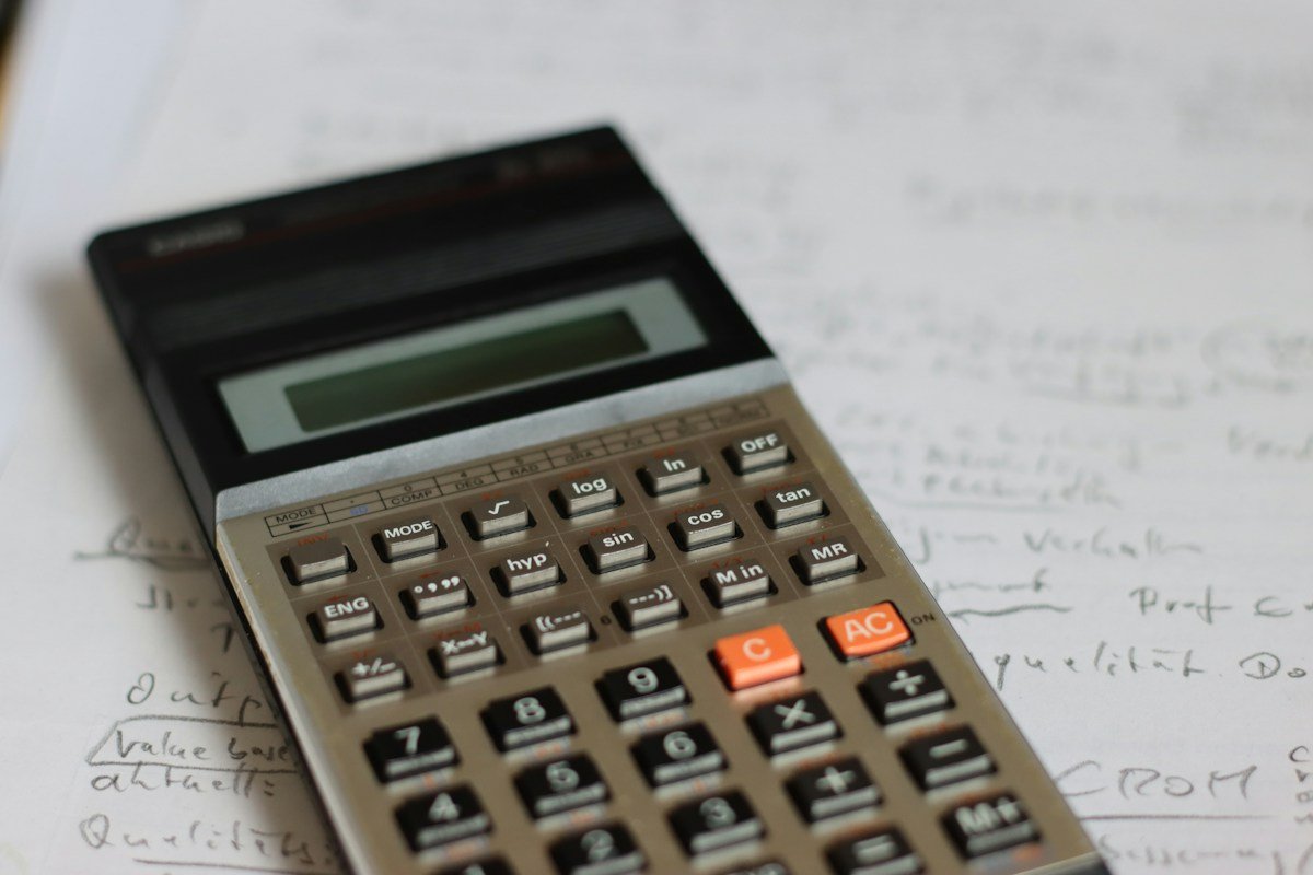Calculatrice ancienne posée sur des notes manuscrites