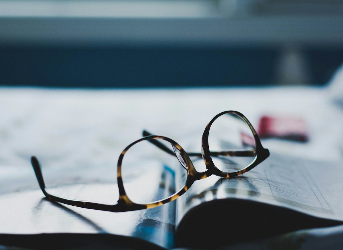 Lunettes posées sur un journal ouvert