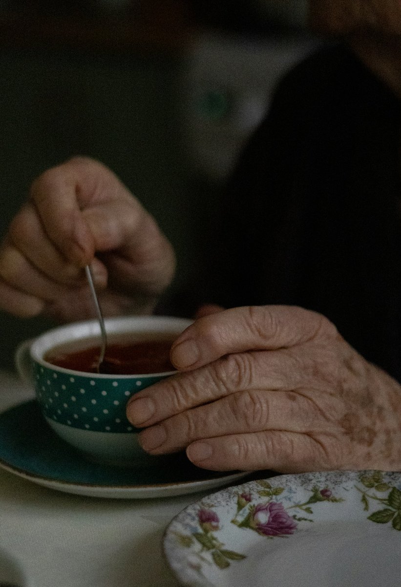 Mains âgées remuant une tasse de thé