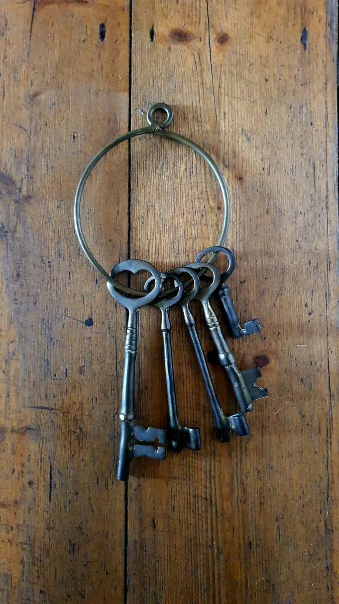 Trousseau de vieilles clés suspendu à une porte en bois